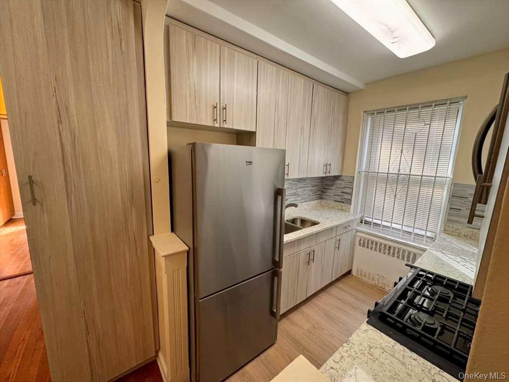 63-60 102nd Street, Unit A7 Queens, NY 11374 - Photo 7 of 15 a kitchen with a refrigerator sink and cabinets