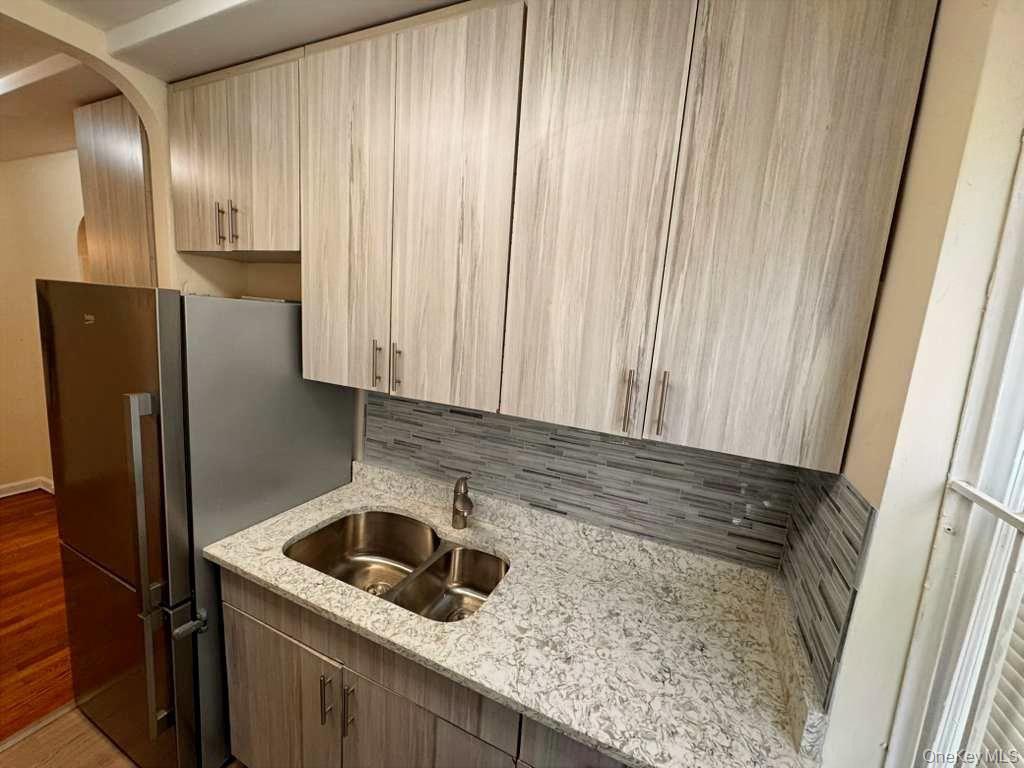 63-60 102nd Street, Unit A7 Queens, NY 11374 - Photo 10 of 15 a kitchen with a sink a refrigerator and cabinets