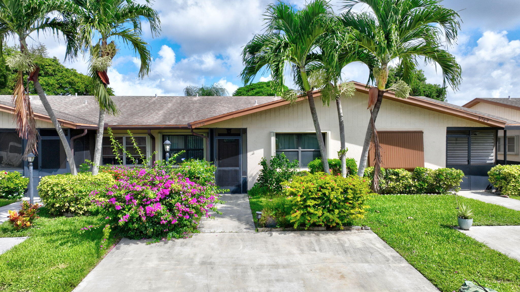 5775 Wanda Lane Delray Beach, FL 33484 - Photo 2 of 73 a front view of a house with a garden and potted plants