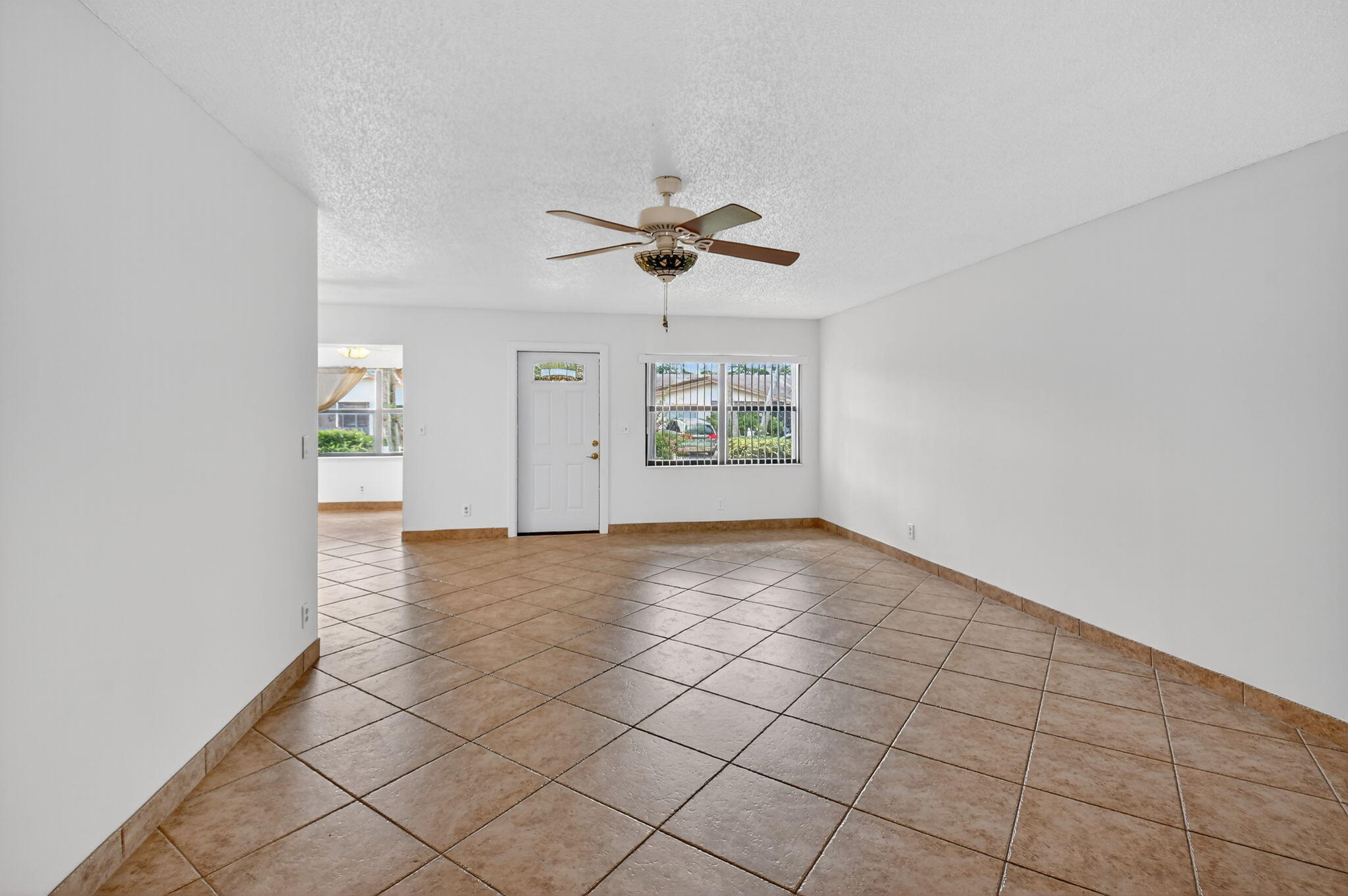 5775 Wanda Lane Delray Beach, FL 33484 - Photo 5 of 73 an empty room with windows and fan