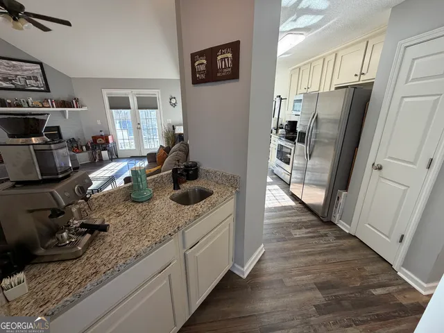 a kitchen with stainless steel appliances granite countertop a sink stove and cabinets