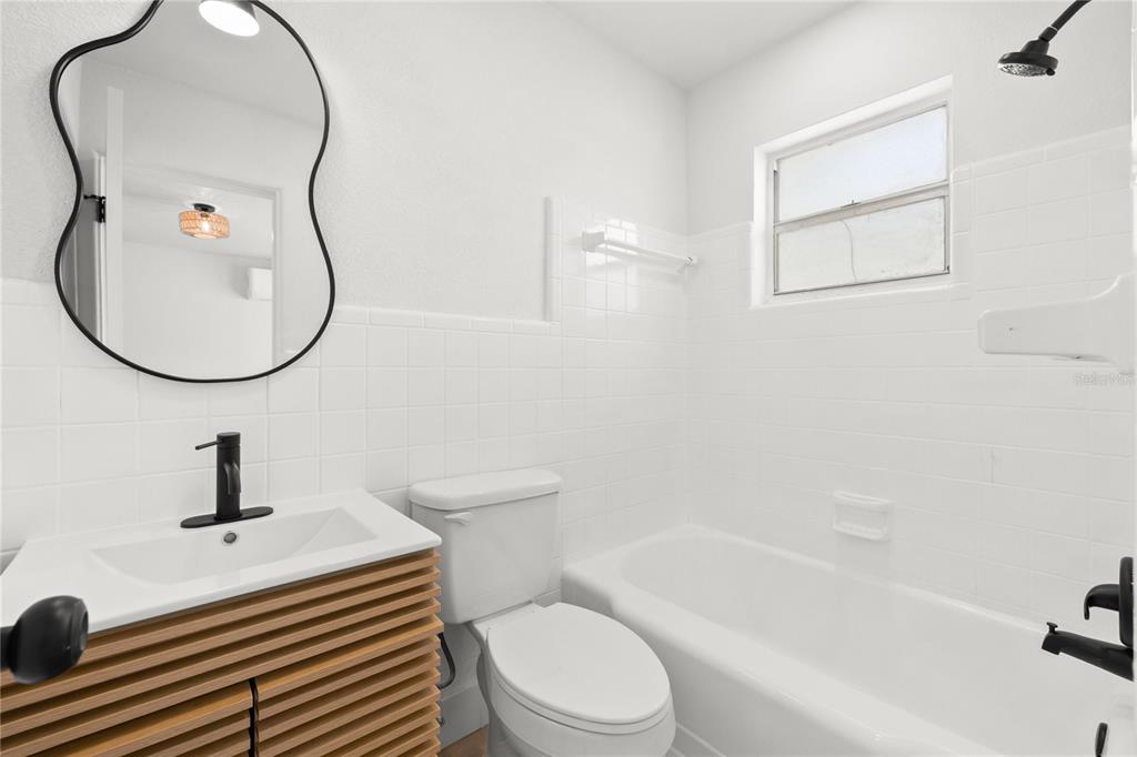 13388 1st Street East Madeira Beach, FL 33708 - Photo 16 of 28 a bathroom with a toilet sink a mirror and vanity