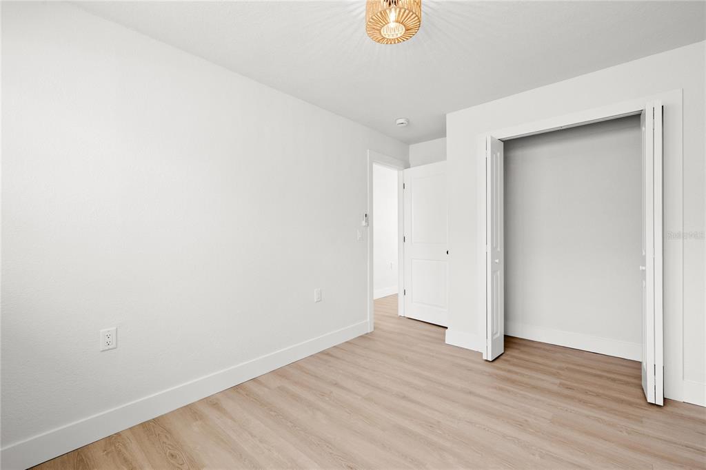 13388 1st Street East Madeira Beach, FL 33708 - Photo 20 of 28 a view of an empty room with wooden floor and a window