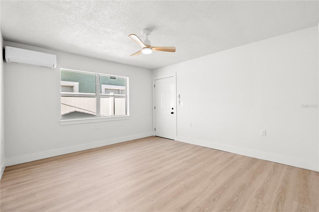 13388 1st Street East Madeira Beach, FL 33708 - Photo 25 of 28 an empty room with windows and fan