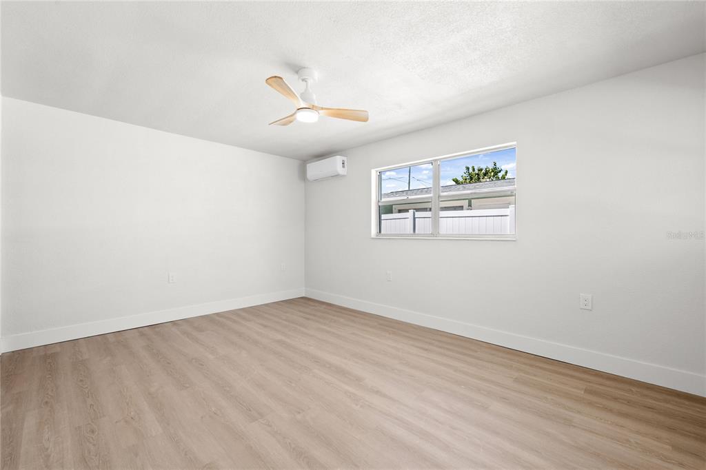 13388 1st Street East Madeira Beach, FL 33708 - Photo 8 of 28 an empty room with wooden floor and windows