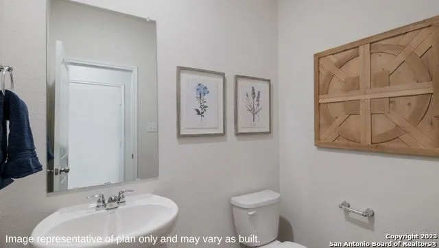 a bathroom with a toilet a sink and a mirror