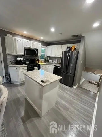 a kitchen with kitchen island a refrigerator stove and microwave