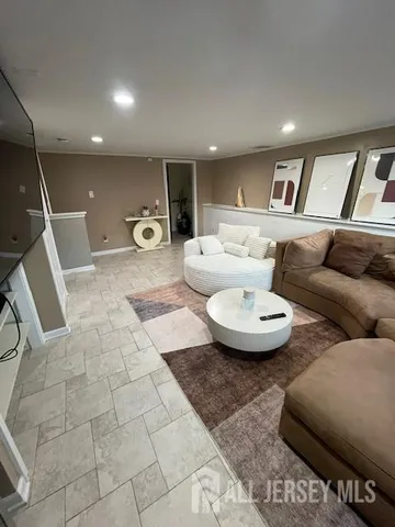 a living room with furniture and a view of kitchen