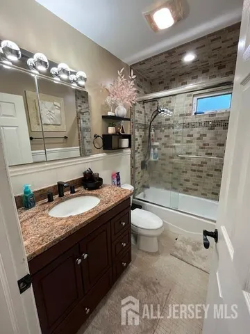 a bathroom with a granite countertop sink toilet and shower