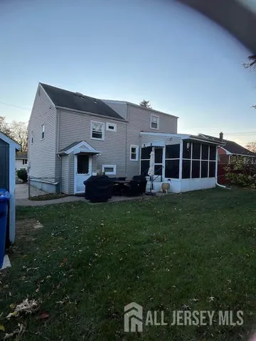 a backyard of a house with plants and large tree