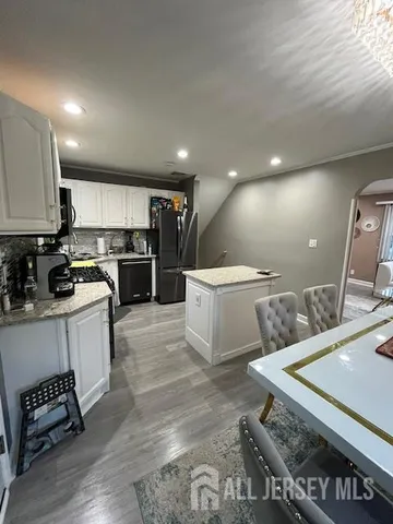 a large white kitchen with a stove a sink a refrigerator and a cabinets