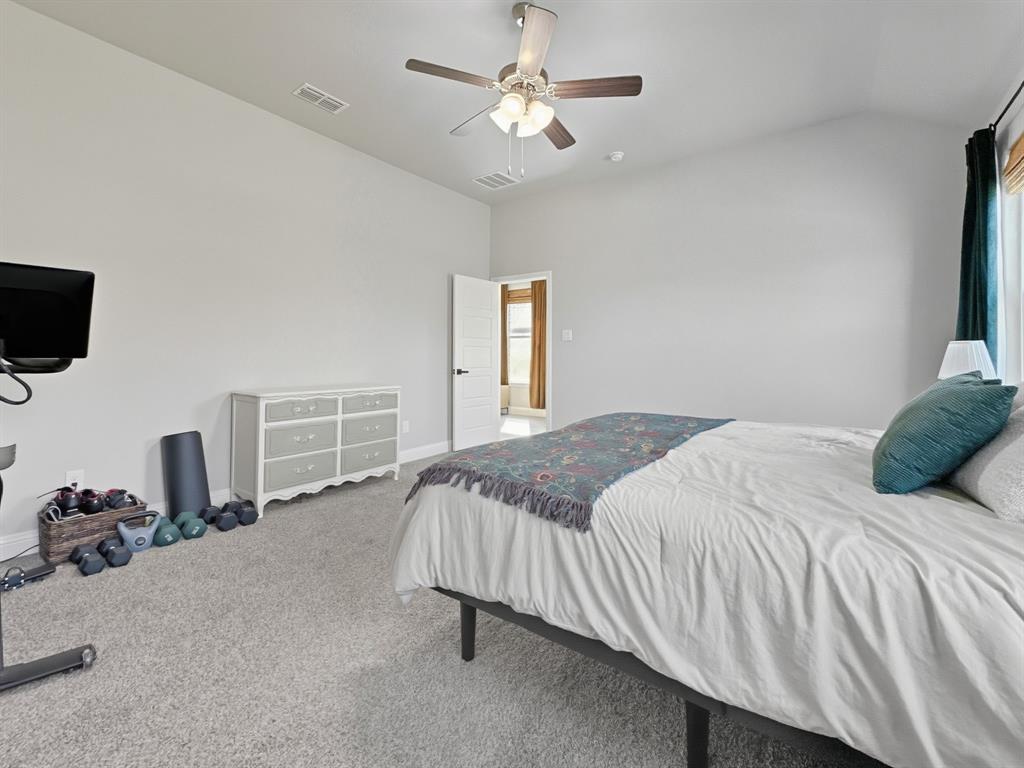 2216 Redwing Drive Denton, TX 76205 - Photo 19 of 38 a bedroom with a bed and a chandelier