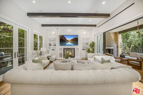 a living room with furniture fireplace and a large window