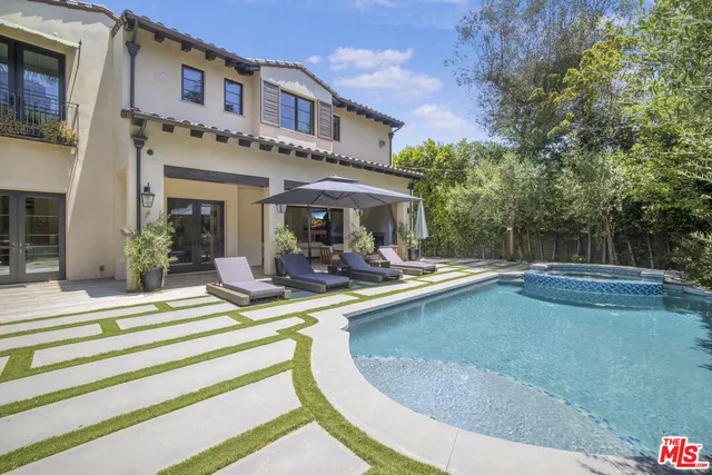 a view of a house with swimming pool and sitting area