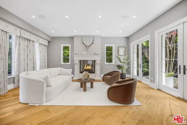 a living room with furniture fireplace and a large window