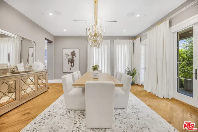 a living room with dining table and a large window