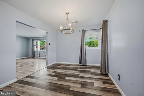 a view of a hallway with window and chandelier