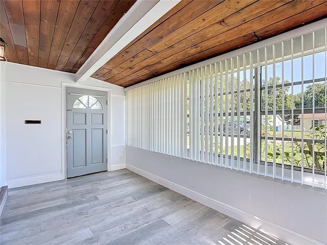 a view of an empty room with wooden floor