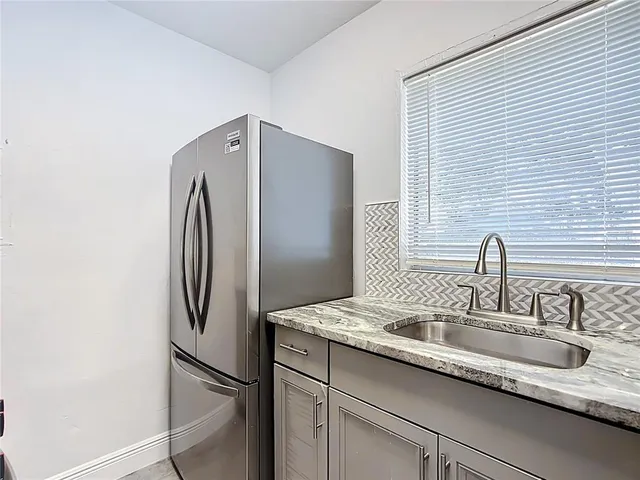 a kitchen with stainless steel appliances granite countertop a refrigerator and a sink