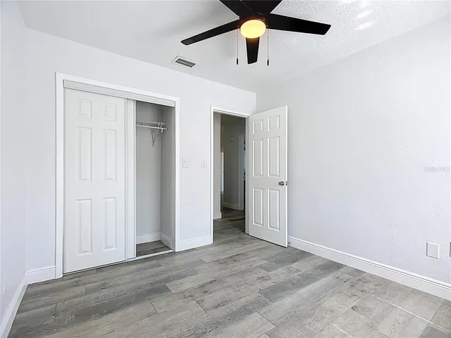 an empty room with a ceiling fan and carpet