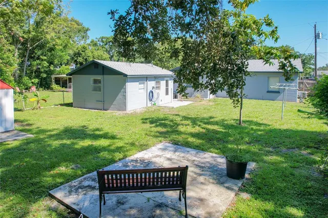 a view of a house with a yard and fence