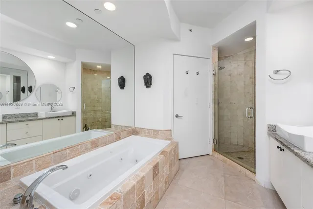 a spacious bathroom with a tub sink shower and mirror