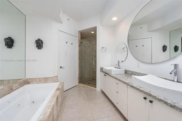 a spacious bathroom with a granite countertop sink mirror and bathtub