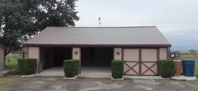 a front view of a house with garden and trees