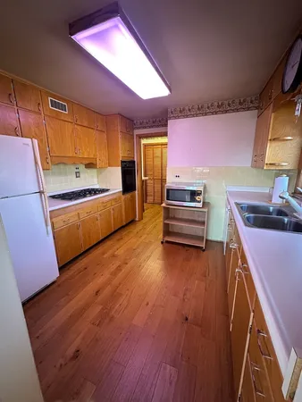 a bathroom with a granite countertop sink a mirror and shower