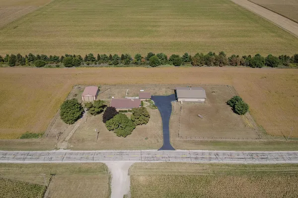 an aerial view of a house with big yard and large trees