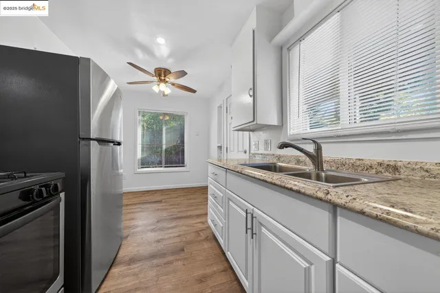 a kitchen with granite countertop a sink stainless steel appliances and cabinets