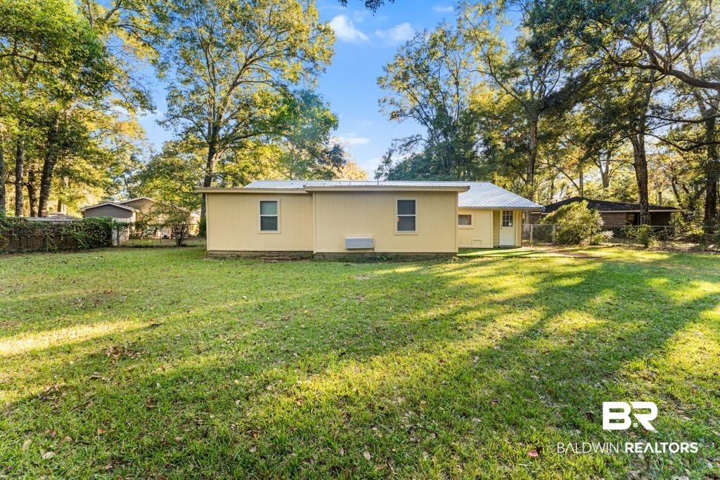 5551 Springer Court Theodore, AL 36582 - Photo 13 of 37 Rear view of property featuring a metal roof and view of scattered trees