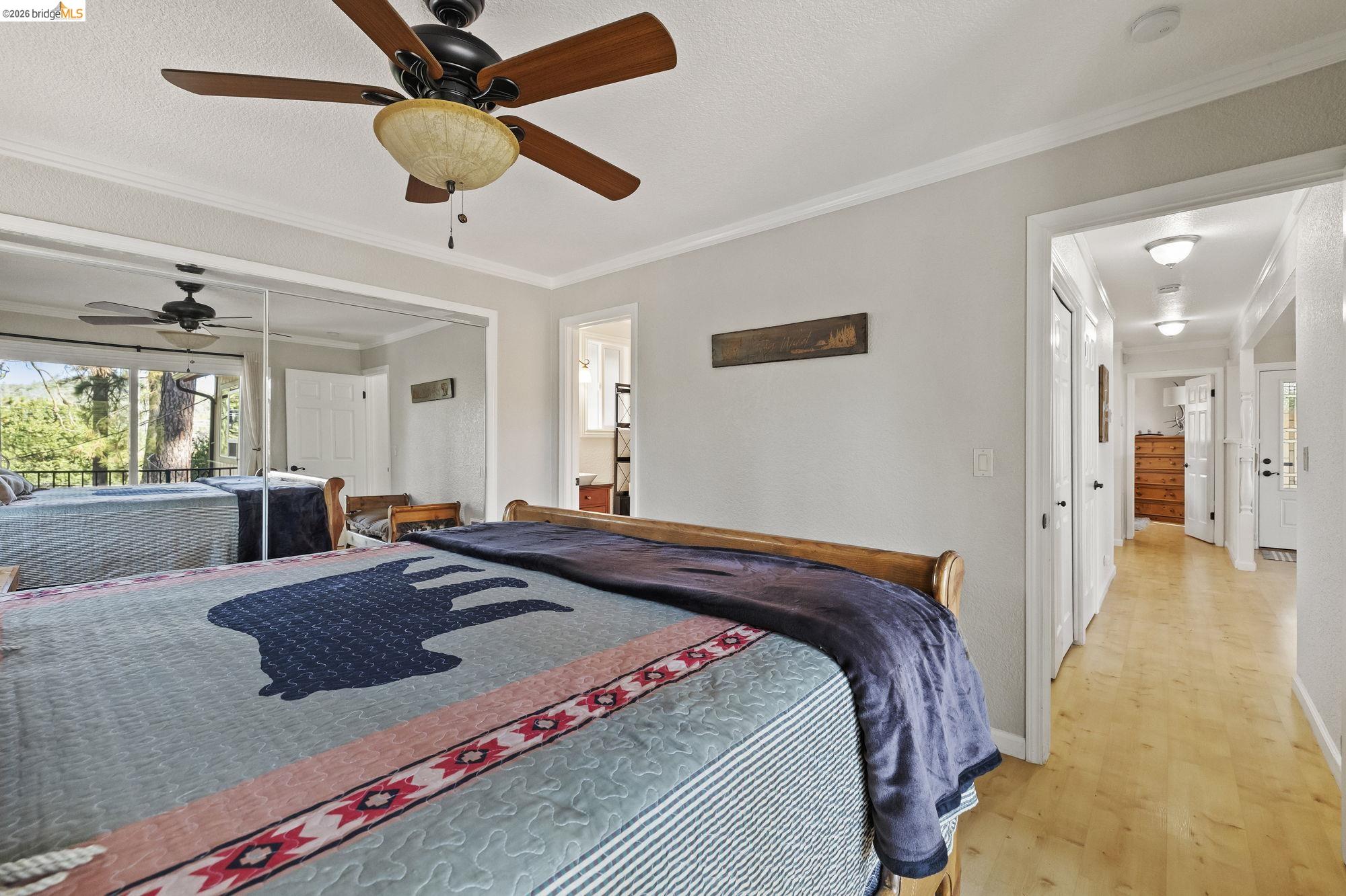 19369 Ferretti Road Groveland, CA 95321 - Photo 23 of 45 Bedroom with ornamental molding, light wood-type flooring, a ceiling fan, and a textured ceiling