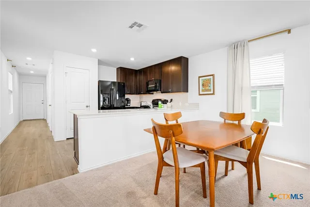 a living room with furniture kitchen view and a large window
