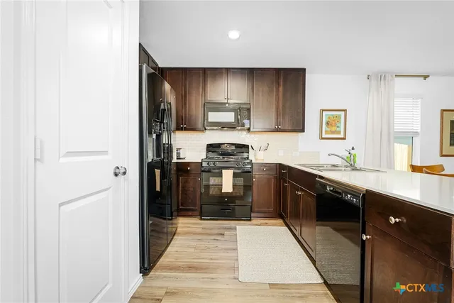 a kitchen with stainless steel appliances granite countertop a refrigerator and a stove