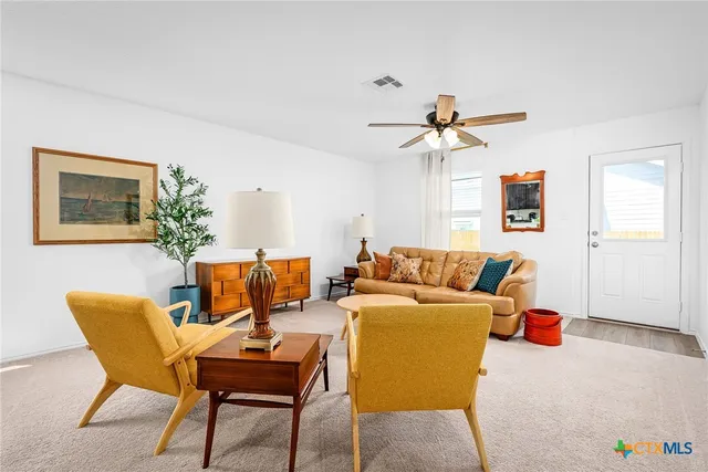 a living room with furniture a chandelier and a potted plant