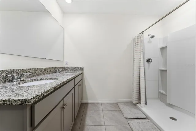 a bathroom with a granite countertop sink and shower