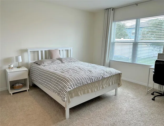 a bedroom with a bed chair and a window