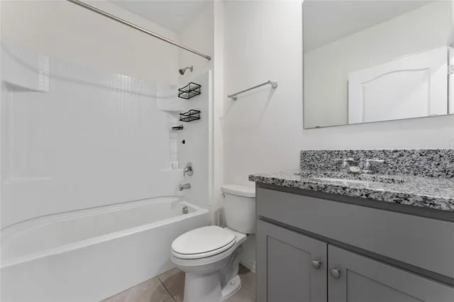 a bathroom with a granite countertop toilet a sink and bathtub