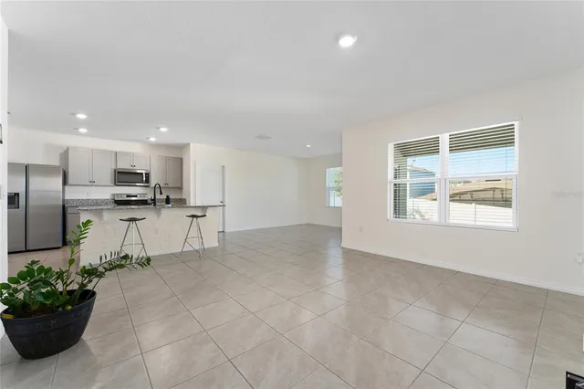 a view of kitchen with stainless steel appliances kitchen island granite countertop a refrigerator and a sink
