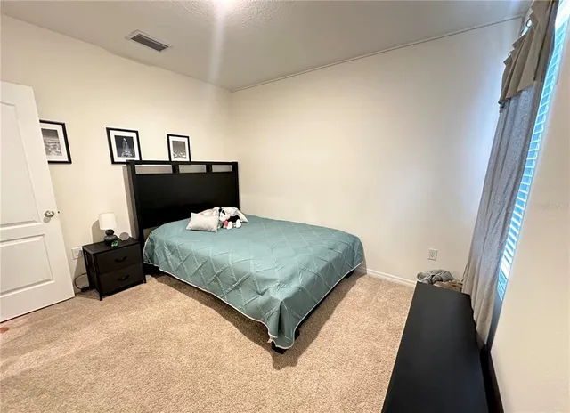 a bedroom with a bed and painting on the wall