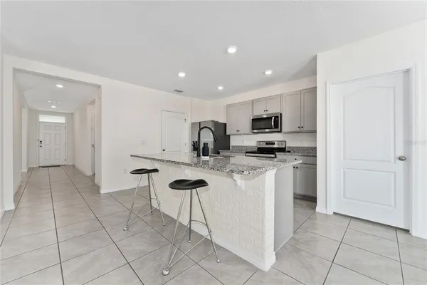 a kitchen with stainless steel appliances granite countertop a sink and a refrigerator
