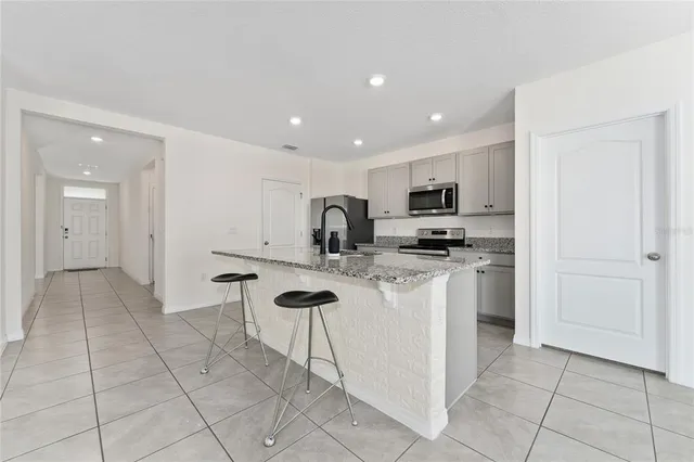 a kitchen with stainless steel appliances granite countertop a sink and a refrigerator