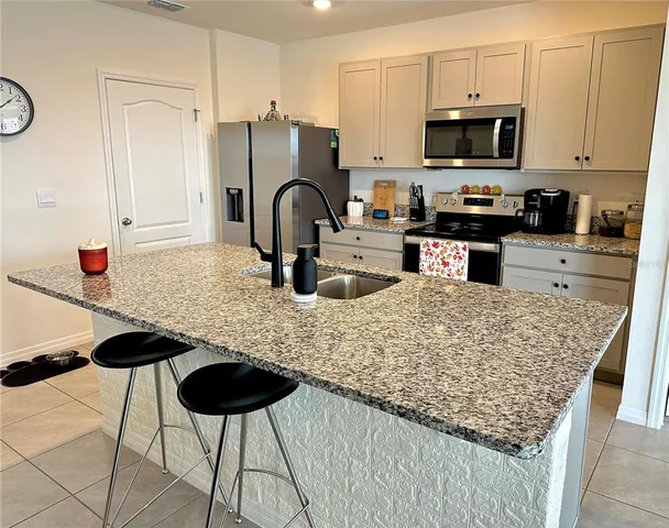a kitchen with stainless steel appliances granite countertop a stove refrigerator and a sink