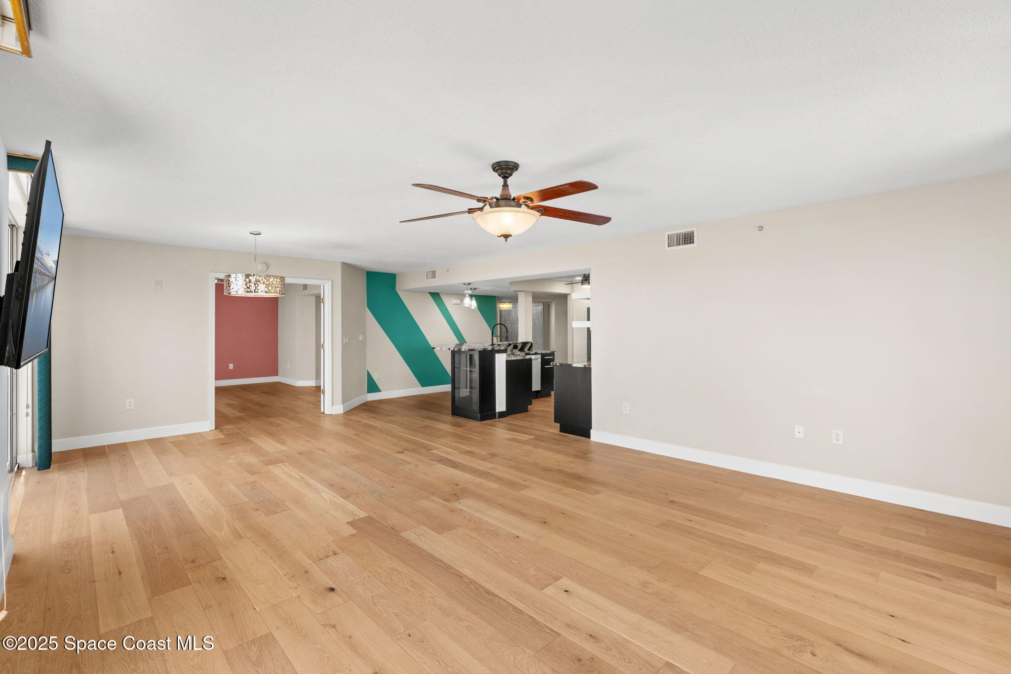 800 Del Rio Way, Unit 401 Merritt Island, FL 32953 - Photo 11 of 45 a view of an empty room with wooden floor and a ceiling fan