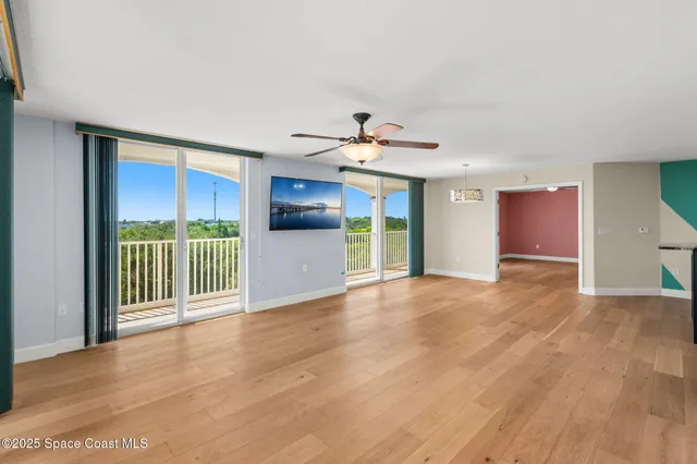 a view of a room with wooden floor and windows