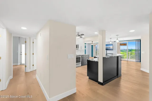 a living room with furniture and a dining table with kitchen view