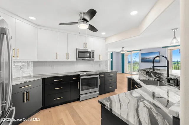 a kitchen with stainless steel appliances granite countertop a sink dishwasher stove and refrigerator