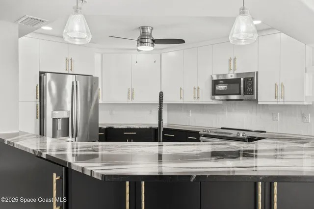 a kitchen with stainless steel appliances granite countertop a sink a refrigerator and a granite counter tops