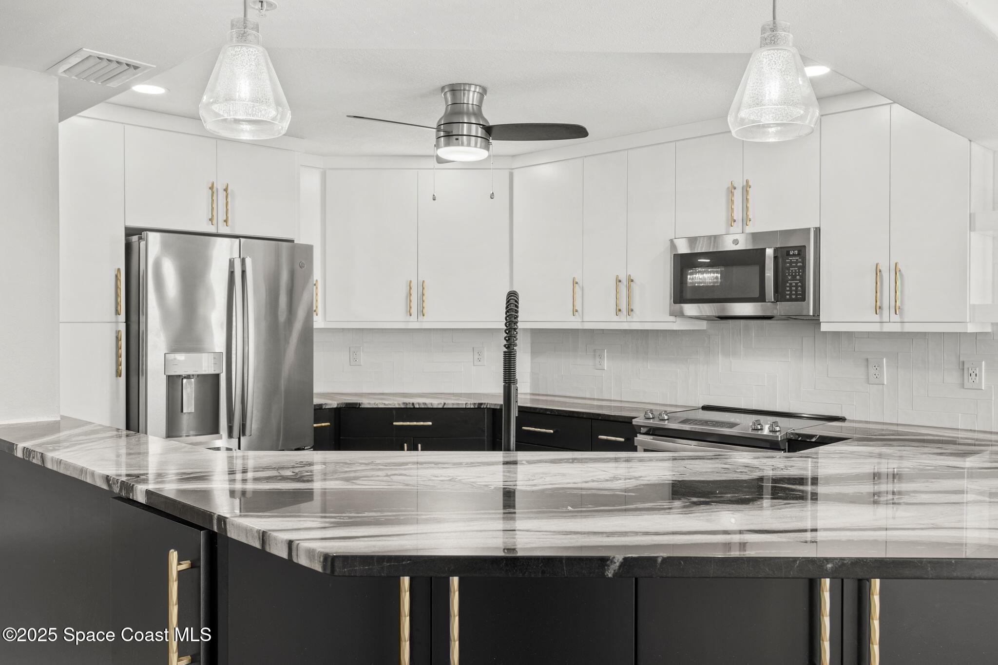 800 Del Rio Way, Unit 401 Merritt Island, FL 32953 - Photo 9 of 45 a kitchen with stainless steel appliances granite countertop a sink a refrigerator and a granite counter tops